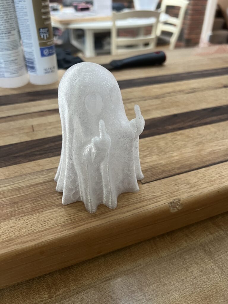 White ghost sitting on a pretty cutting board giving both middle fingers. happy Halloween